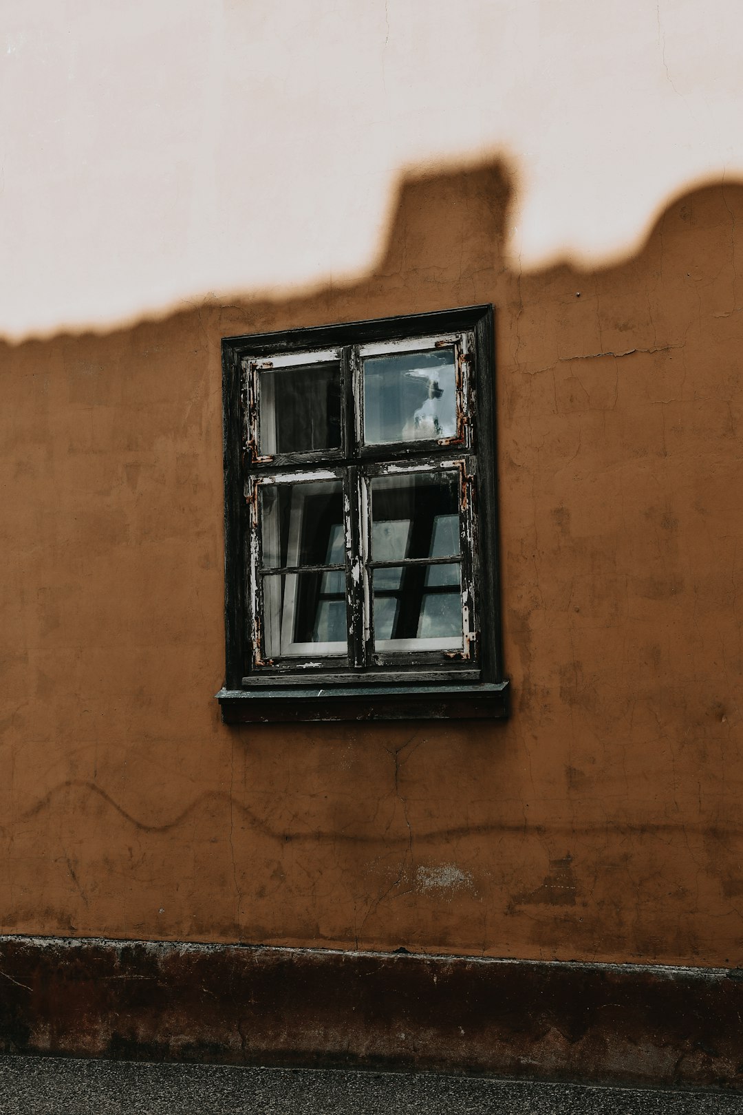 black wooden window frame on brown concrete wall