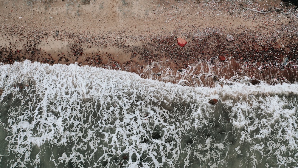 water waves on brown sand during daytime