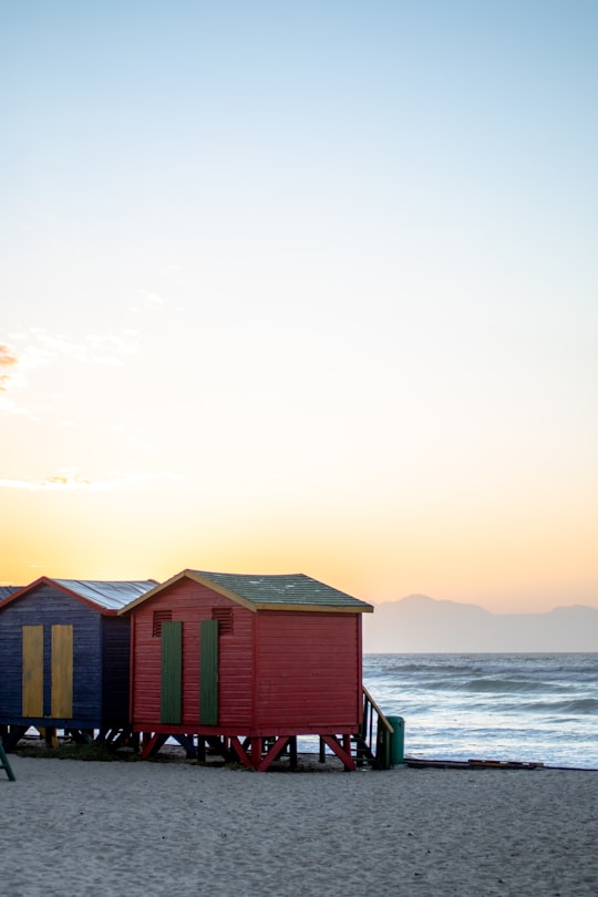 brown wooden house on sea shore during daytime in Muizenberg South Africa