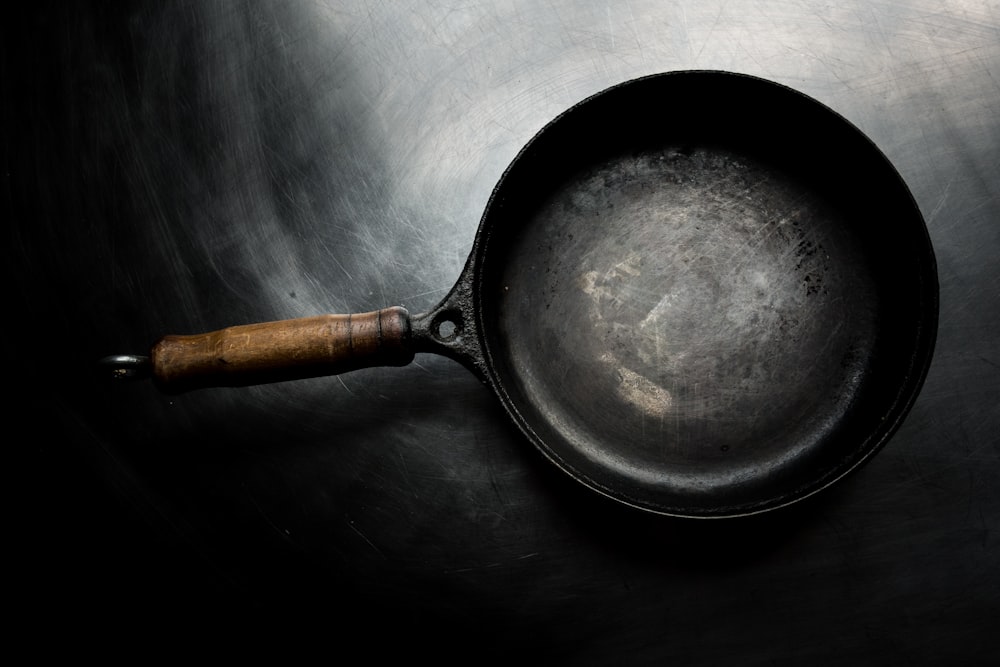 black frying pan on black surface
