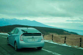 A scenic view of a rental car parked beside a mountain road in Peru.