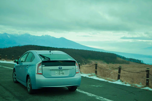 A scenic view of a rental car parked beside a mountain road in Peru.