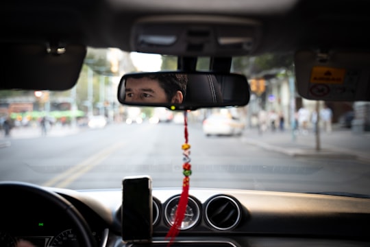 black car rear mirror with red and yellow rope in Montevideo Uruguay