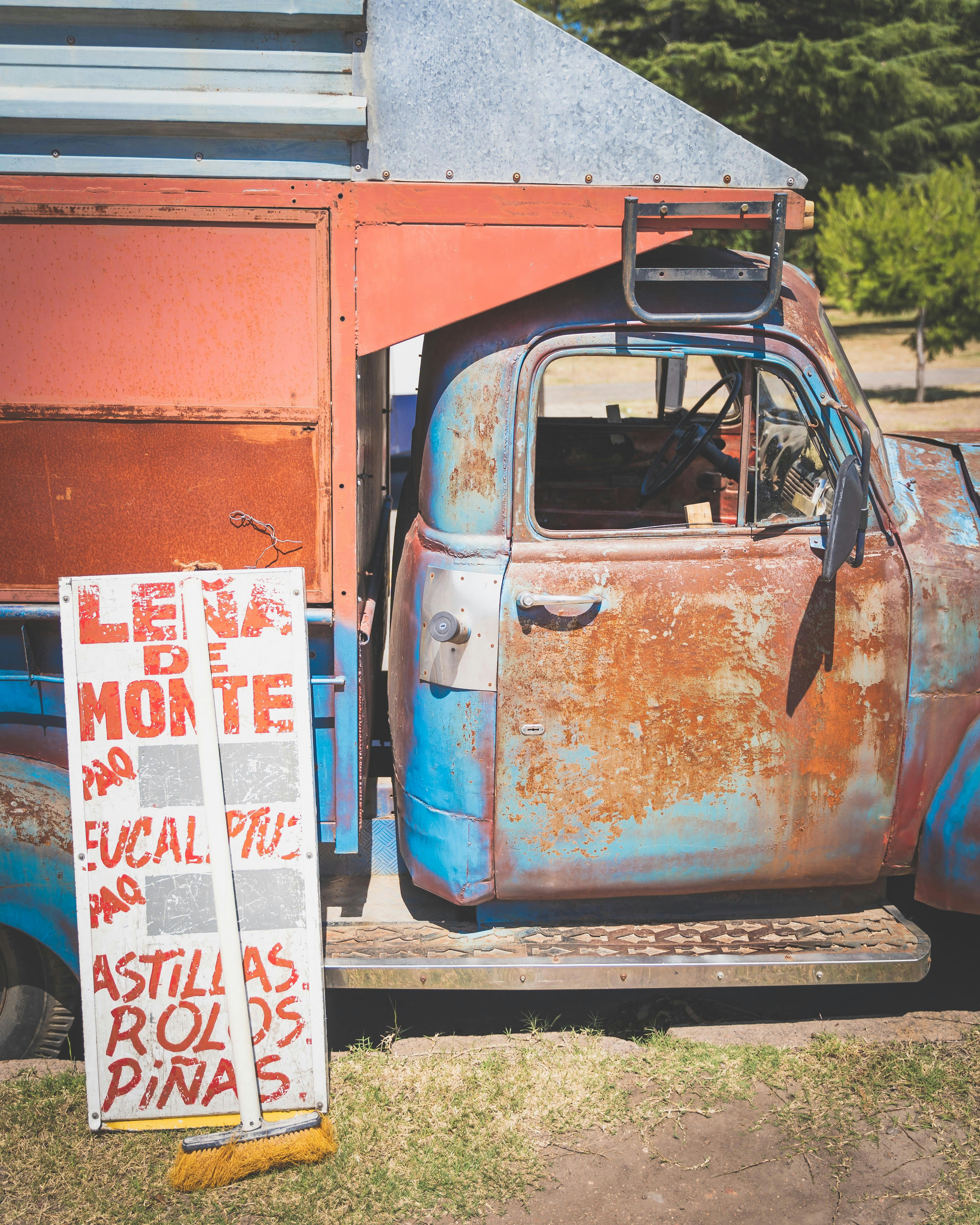 blue and brown car near brown wooden house