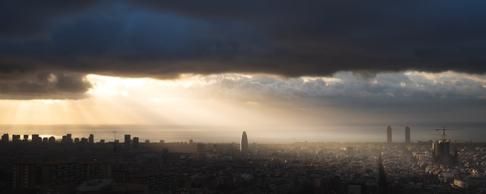 city skyline under blue and white cloudy sky during daytime