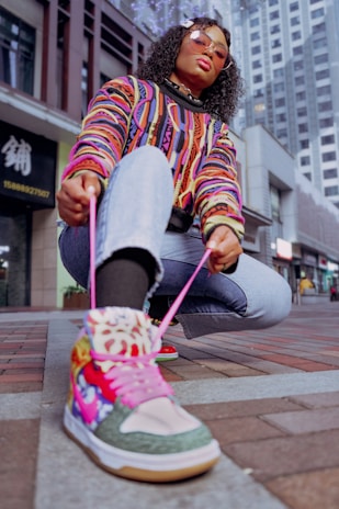 A close-up of a person tying their shoes on a city street, showcasing comfort and fashion.