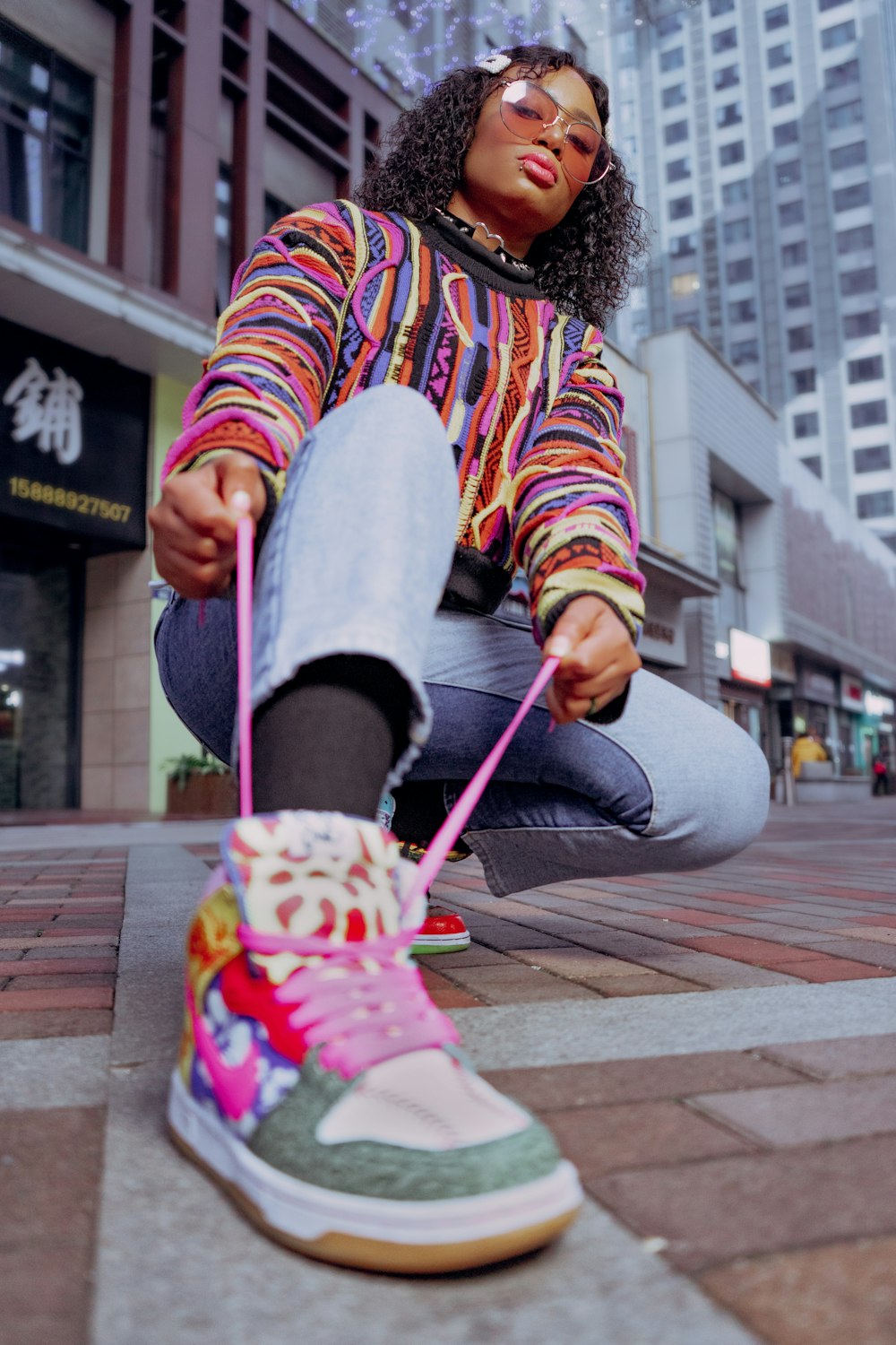 person in white pants and pink white and black stripe running shoes