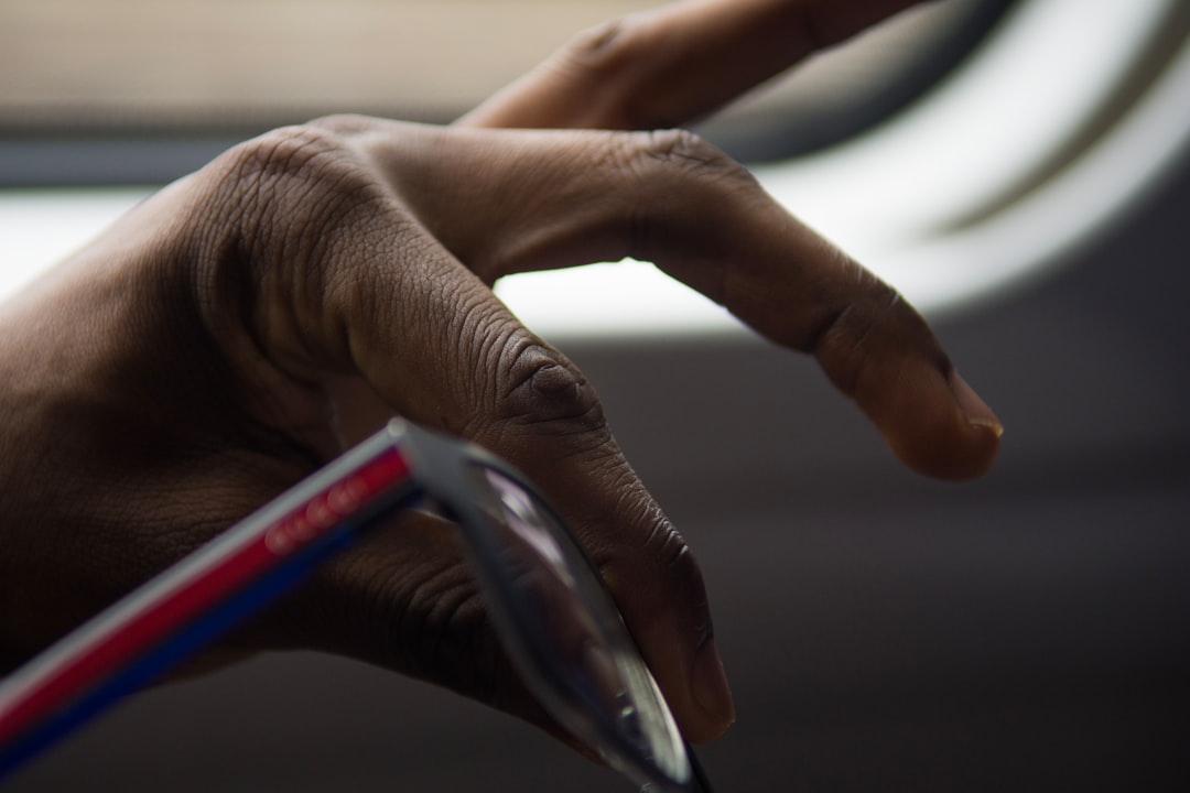 person holding blue and silver click pen