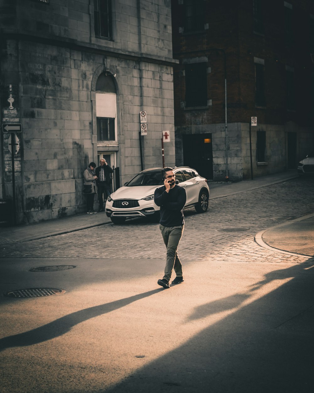 man in black jacket and black pants walking on sidewalk during daytime