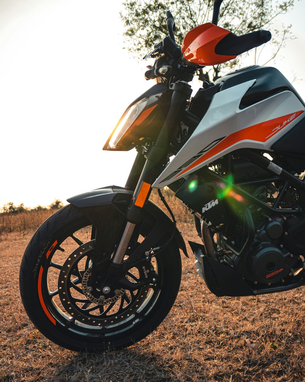 red and white sports bike on brown field during daytime