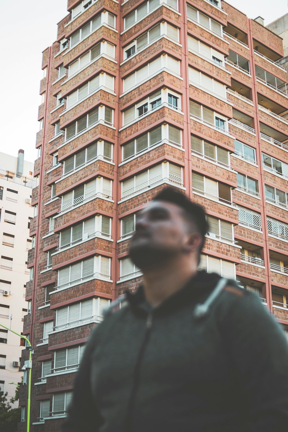 man in black jacket standing near brown concrete building during daytime