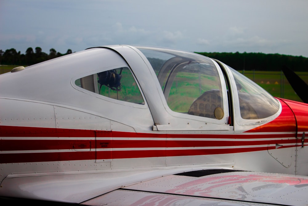 white and red airplane under white clouds during daytime