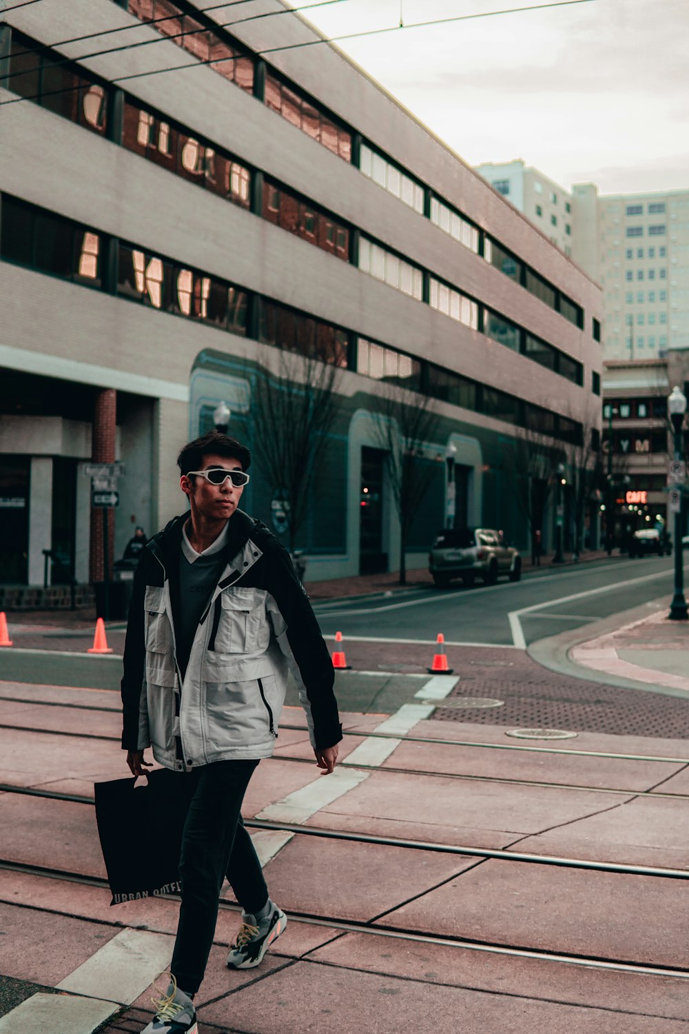 man in gray jacket standing on pedestrian lane during daytime