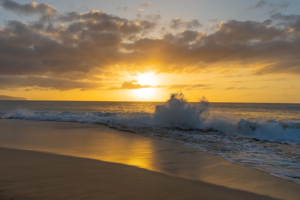 sea waves crashing on shore during sunset