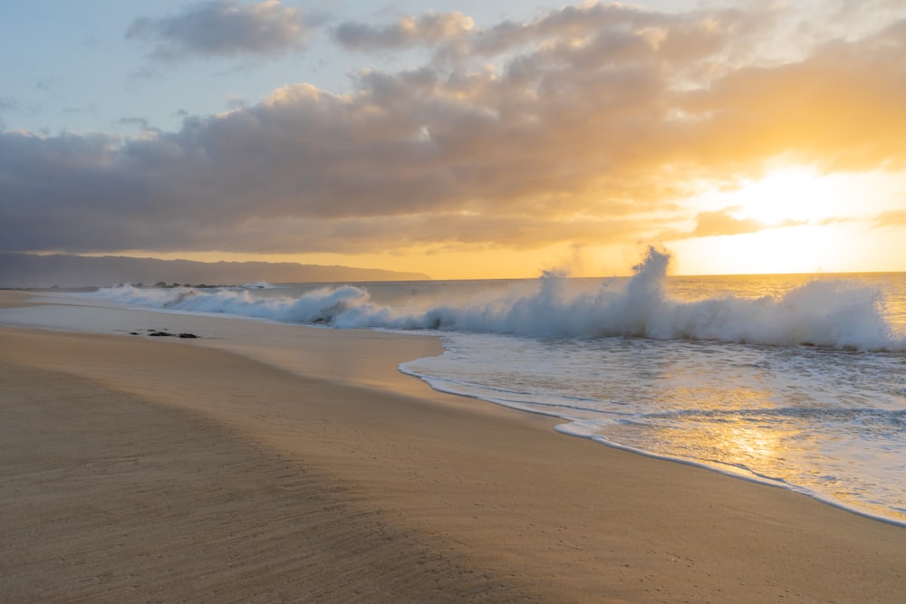 ocean waves crashing on shore during sunset