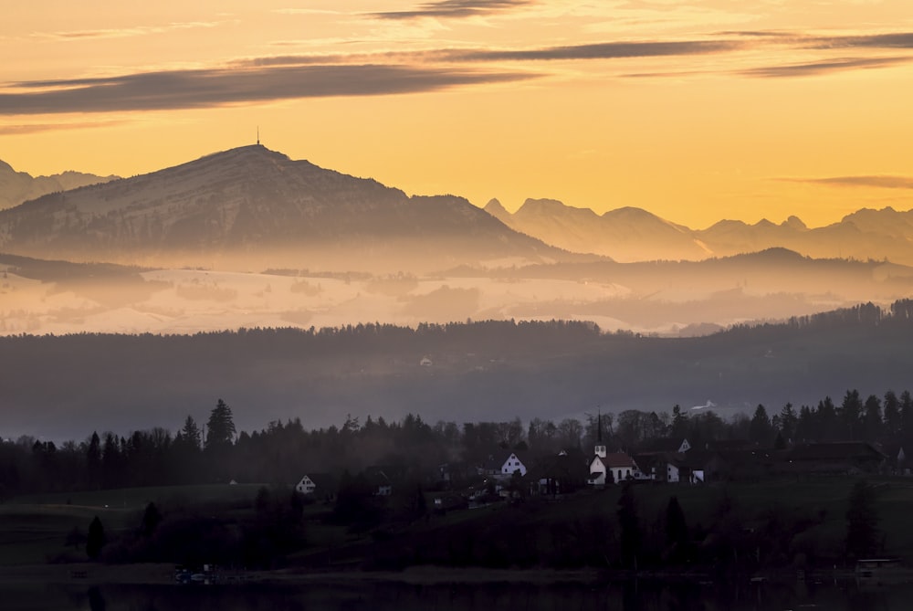 silhouette of trees and mountains during sunset