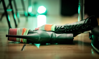 A pair of colorful, patterned socks with a punk rock vibe laid out on a vintage wooden floor.