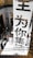 A large vertical banner with bold Chinese characters is displayed, dominating the interior space of a modern building. The architecture features dark reflective surfaces and a combination of industrial and sleek design elements.