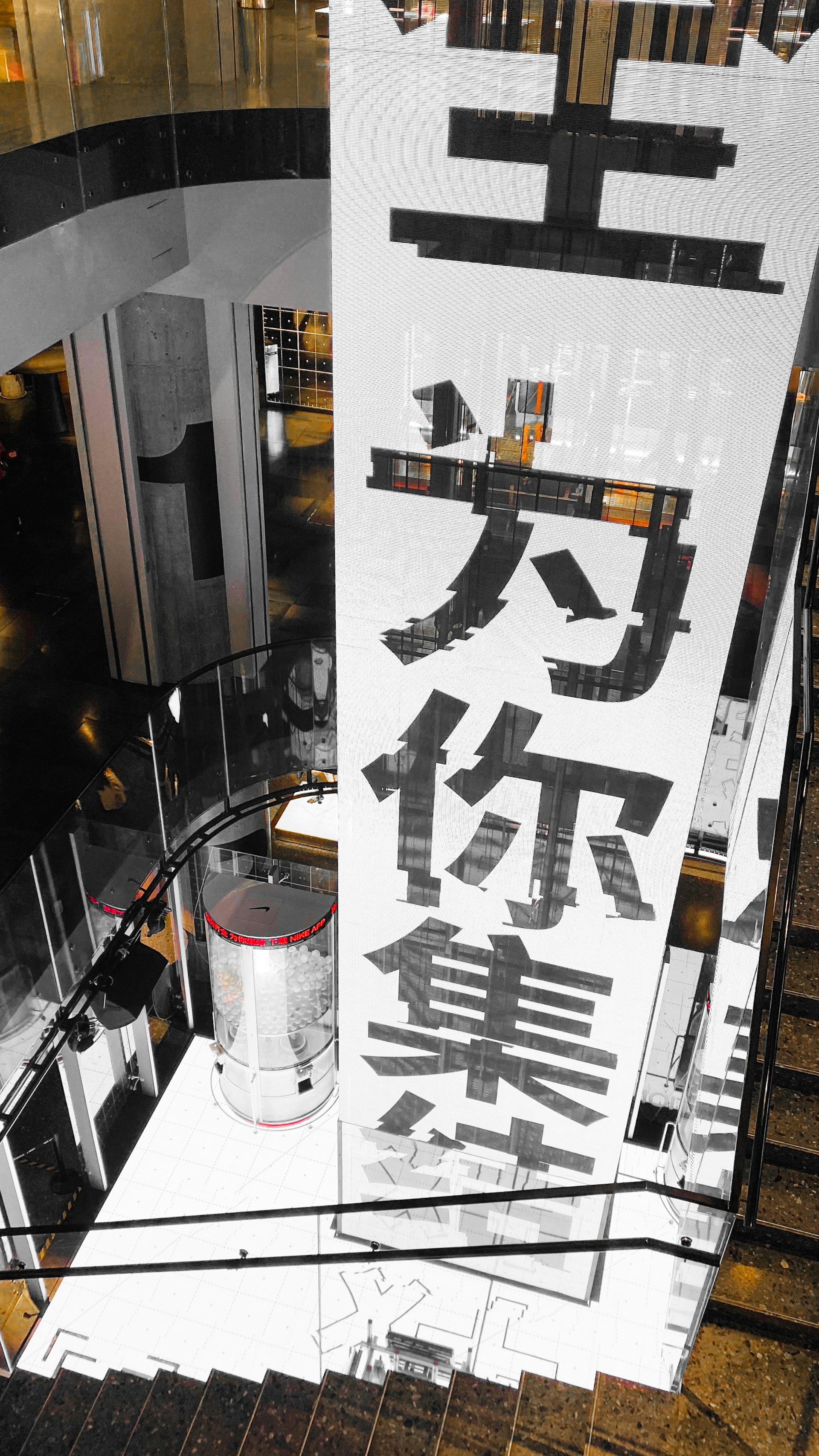 A dynamic shot of a large outdoor banner in black, orange, and white, mounted on a building facade.