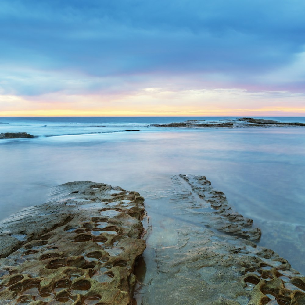 gray rocky shore during sunset