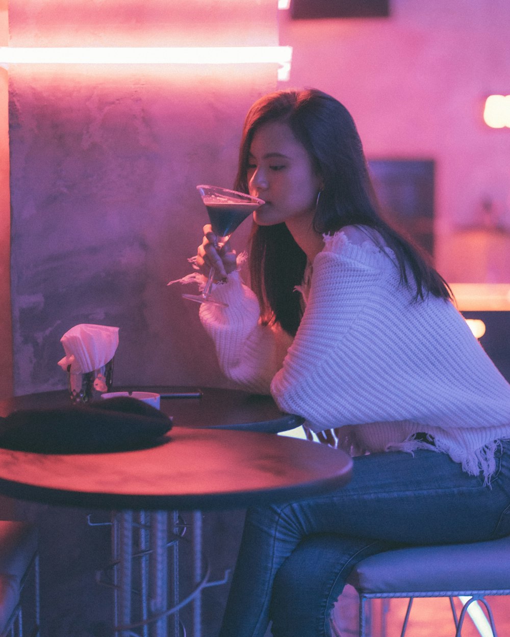 woman in white and black striped long sleeve shirt sitting on black sofa chair