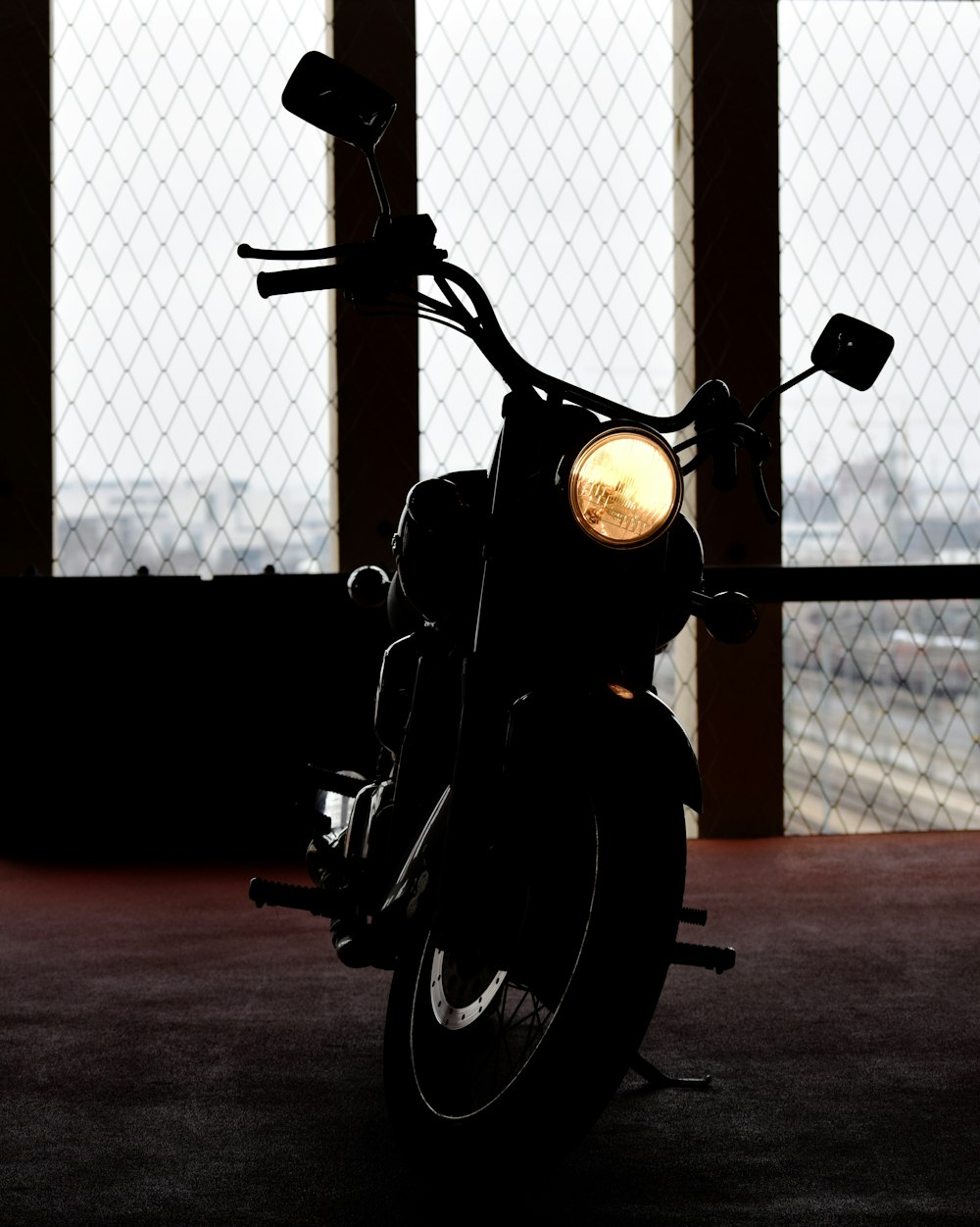 black motorcycle parked beside chain link fence