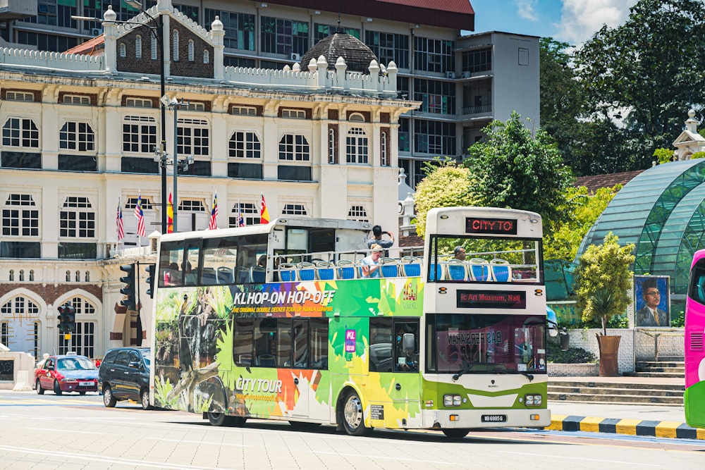 green and white bus on road near building during daytime