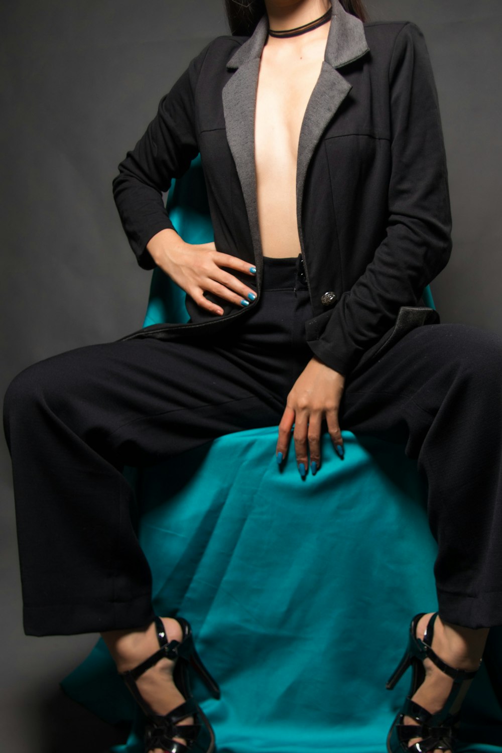 woman in black blazer and black dress pants sitting on blue chair