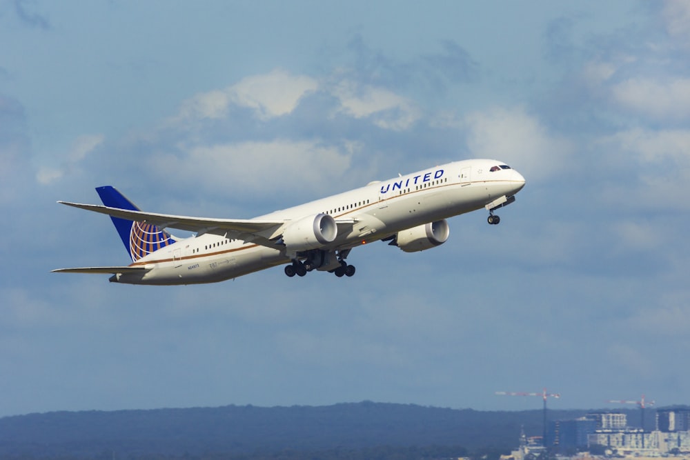 white and blue airplane flying during daytime