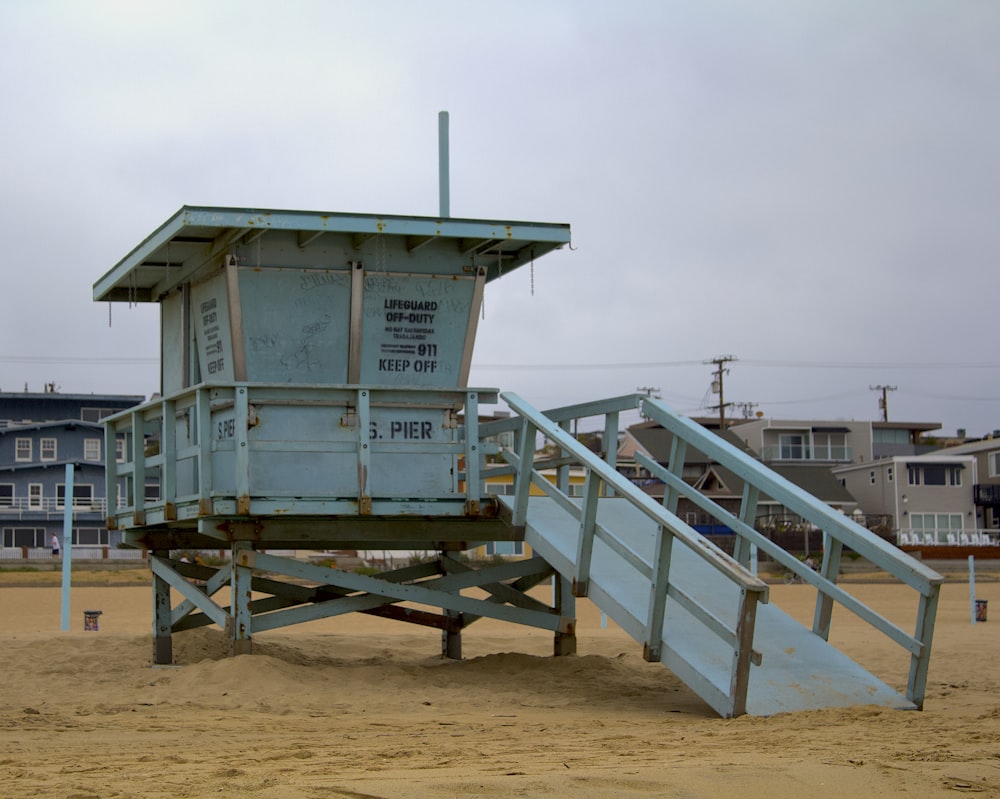 white wooden lifeguard house on beach during daytime