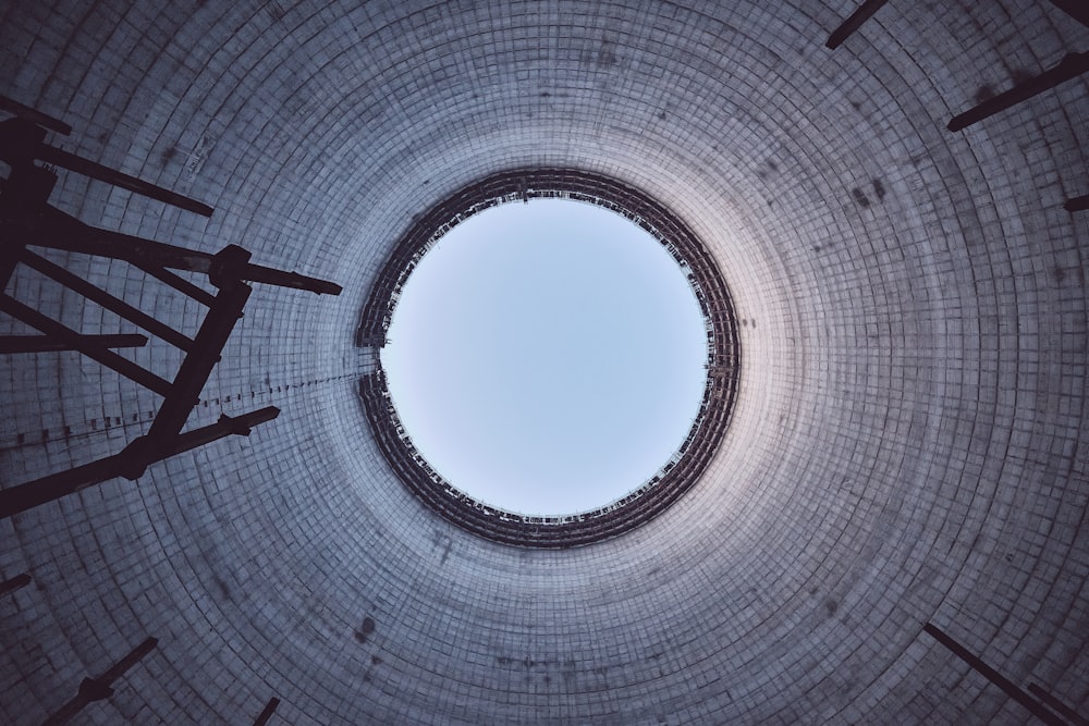 man in black shirt and pants standing on white round ceiling