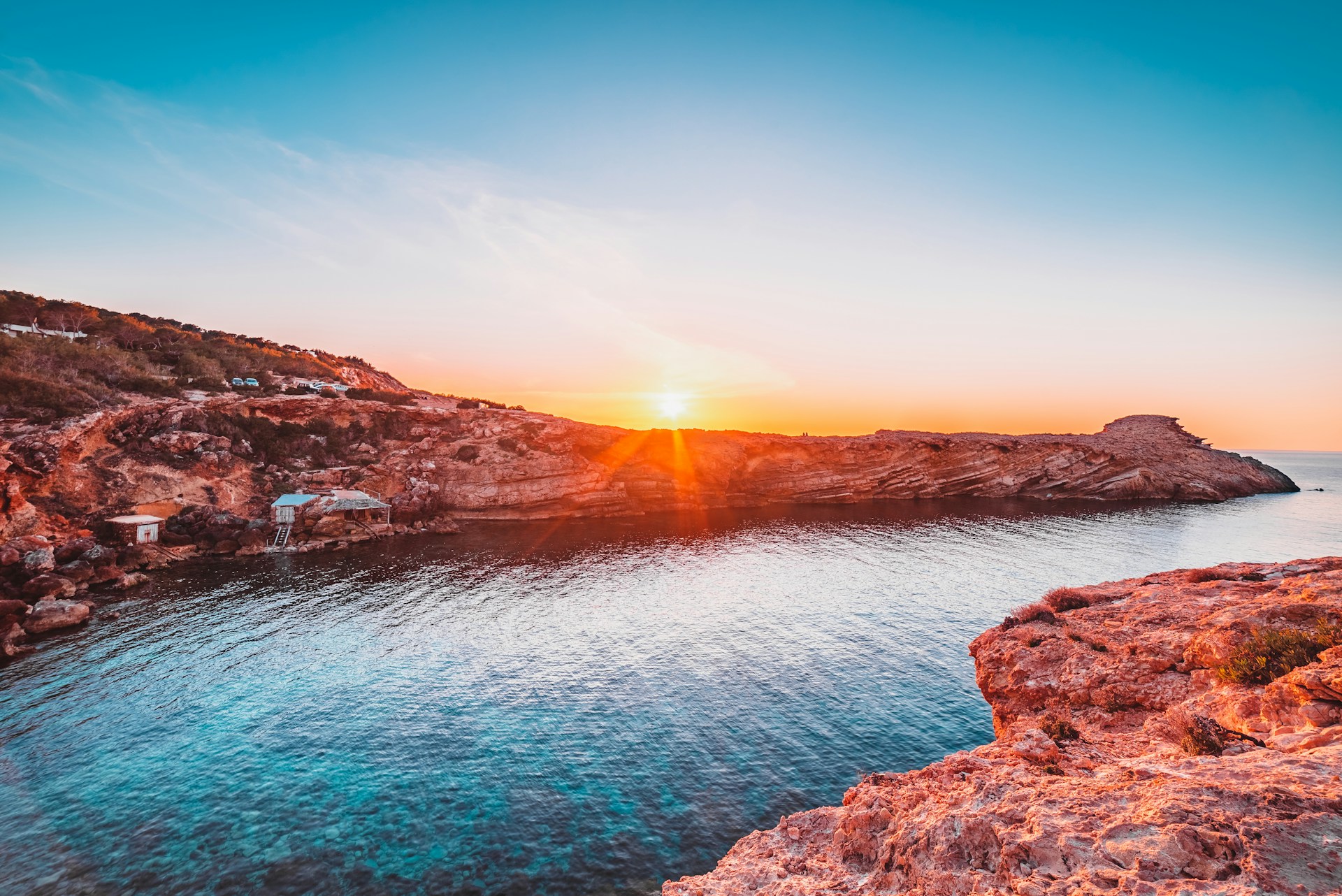 brown rocky mountain beside body of water during sunset