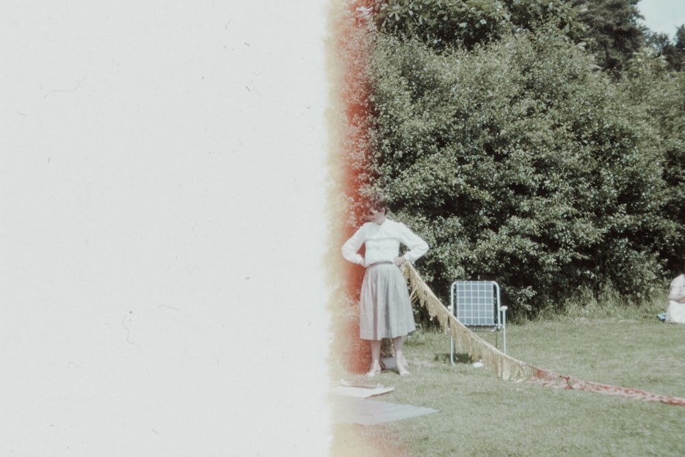 woman in white dress standing on green grass field during daytime