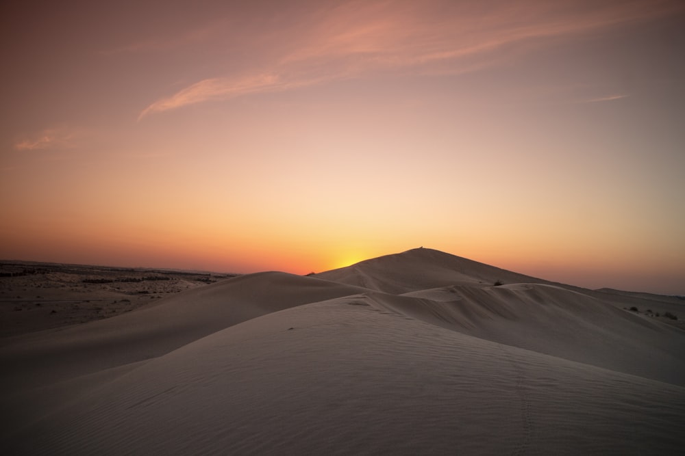 white sand under orange sky during sunset