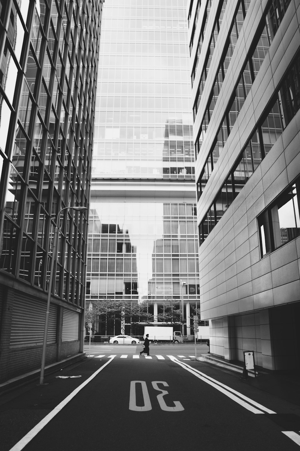 Foto en escala de grises de coches en la carretera cerca de un edificio