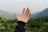 Close-up of hands shaking over a land purchase agreement with green fields behind.