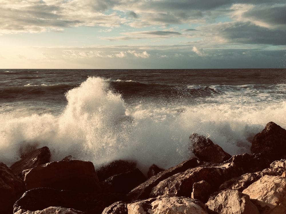 ocean waves crashing on rocks during daytime