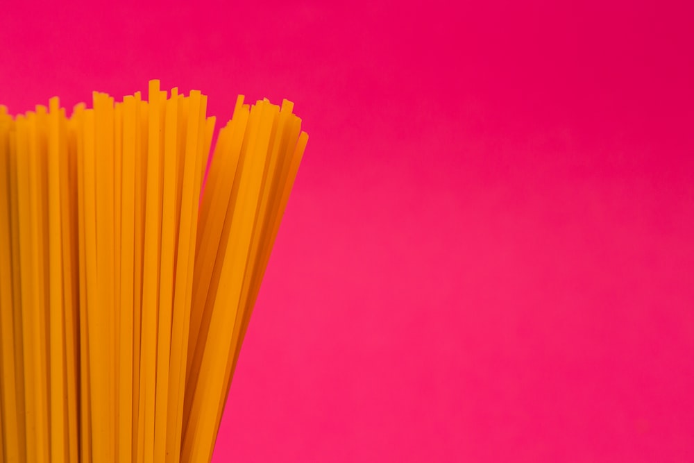yellow plastic sticks on pink surface