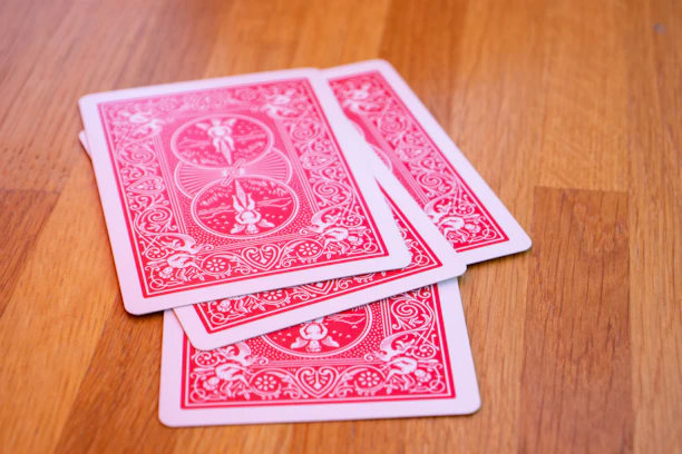 A close-up photo of Tarot de Marseille cards spread out in a fan on a wooden table.