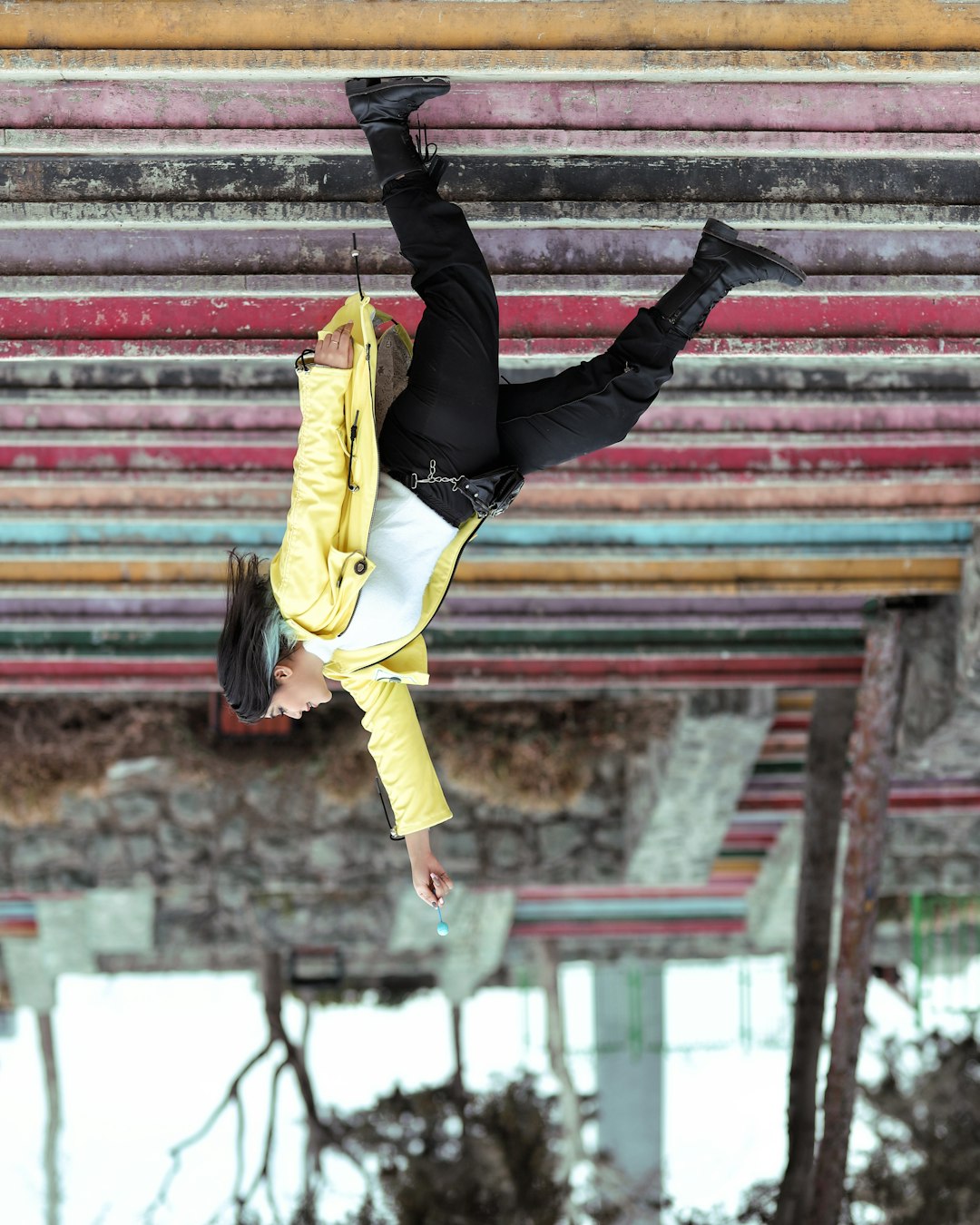 woman in yellow jacket and black pants jumping on red and white wall