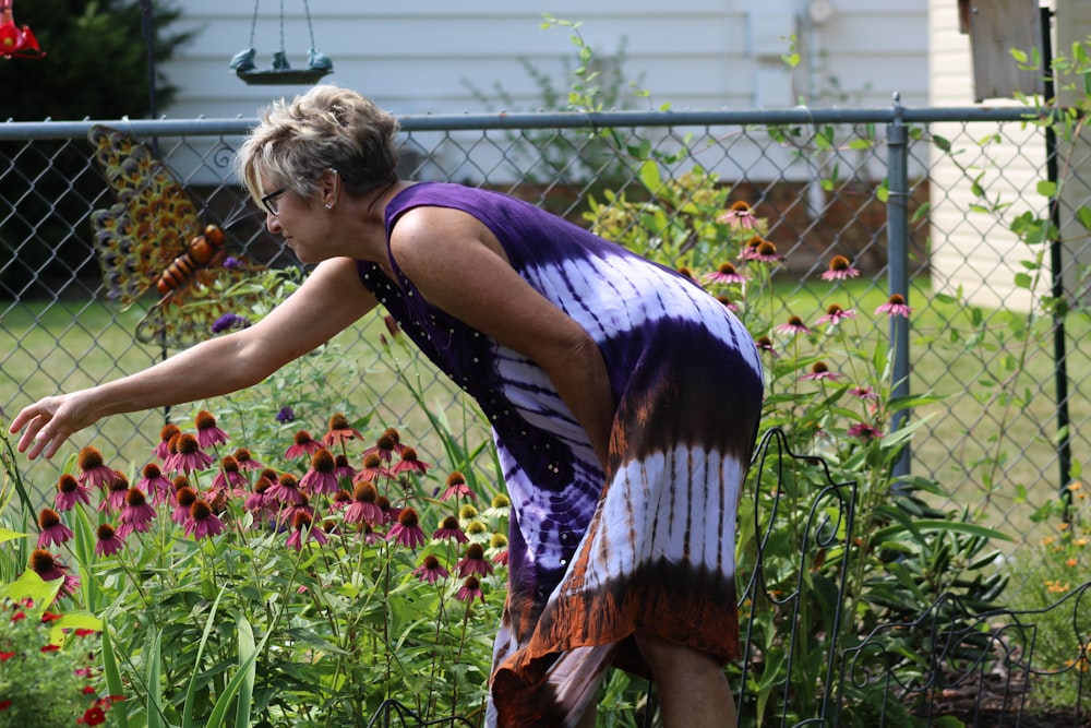 woman in black tank top and orange and white skirt standing on green grass field during