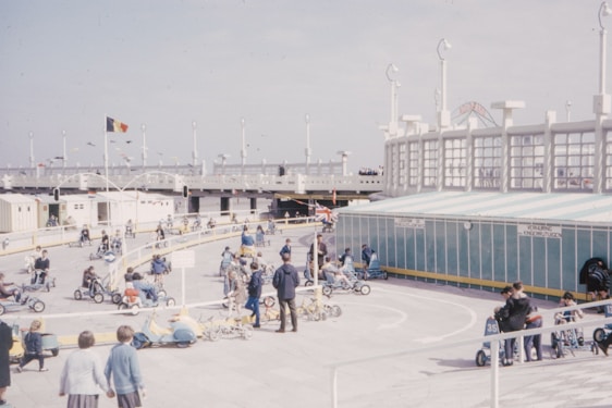 A joyful group of older adults smiling and racing go-karts on a sunny track.