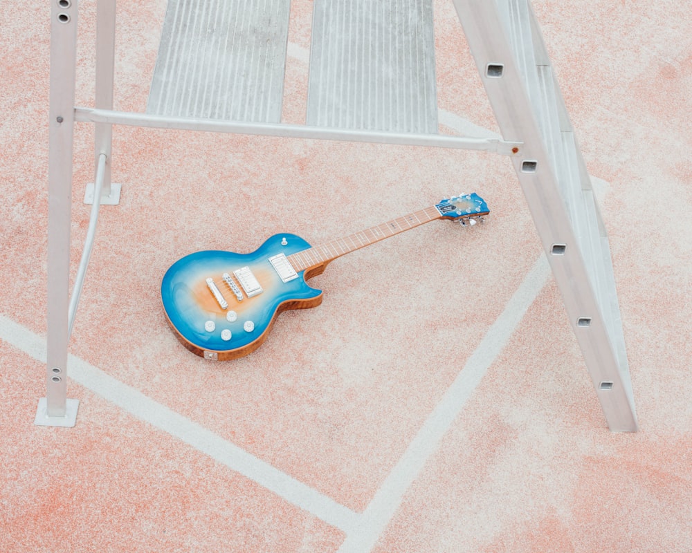 blue and brown guitar on pink and white area rug