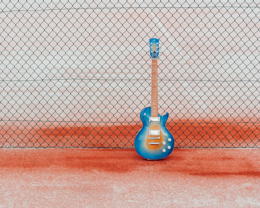 blue and black electric guitar on red and white basketball court