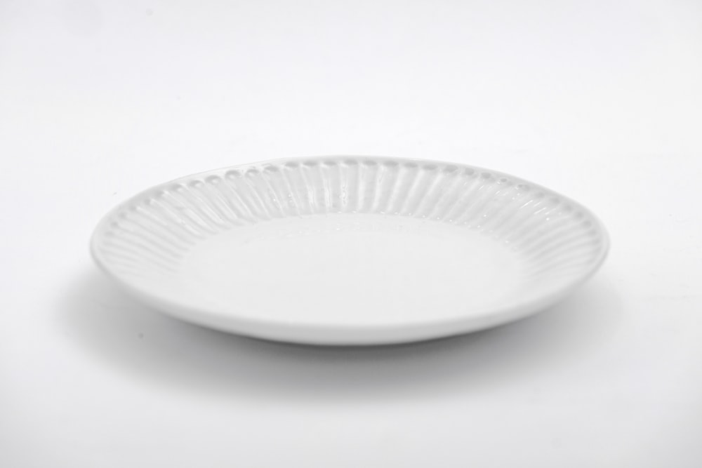 白いテーブルの上に白い丸い皿