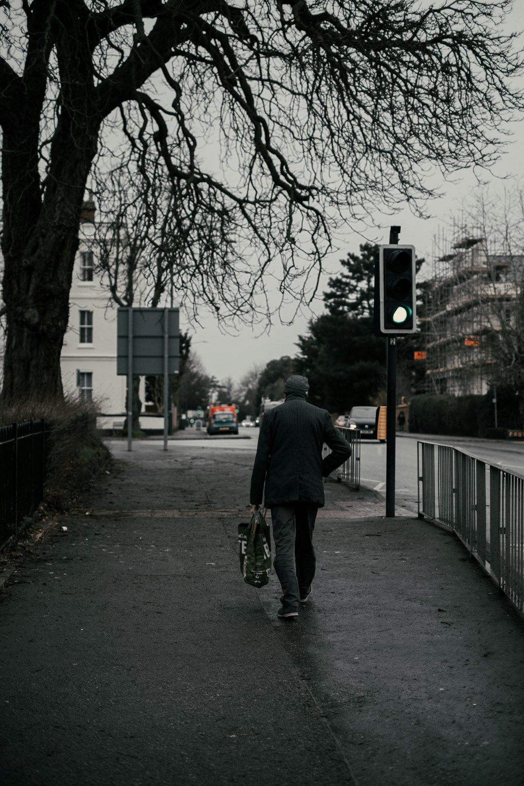 man in gray jacket walking on sidewalk during daytime