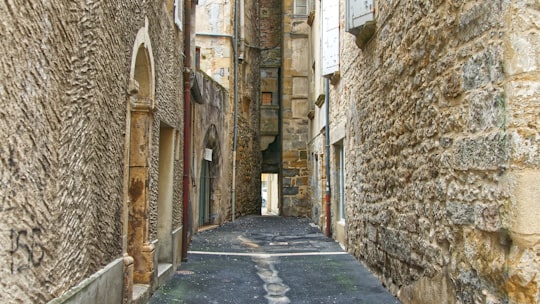 empty street between concrete buildings during daytime in Saint-Céré France