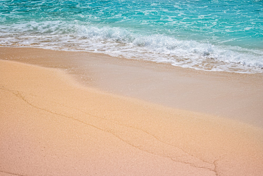 brown sand near body of water during daytime