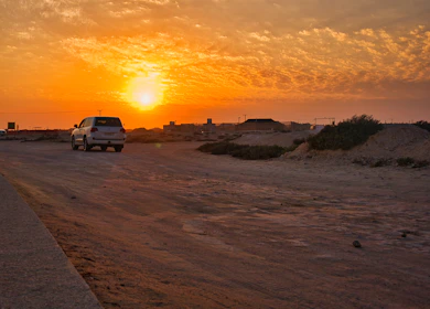 A vehicle driving along a scenic highway outside the city at sunset.