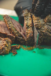 Close-up of a slow-smoked brisket being sliced, smoke swirling around the warm copper tones of the kitchen.